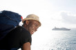 © mimagephotos - handsome young african american travel man smiling by the sea with cruise ship in background