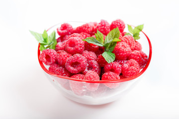 Wall Mural - Ripe sweet raspberries in bowl on white. Close up, top view, high resolution product