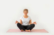 © Alexandr - stylish elderly woman doing yoga on a white background