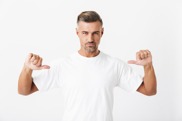 Wall Mural - Image of confident man 30s with bristle wearing casual t-shirt pointing fingers at himself