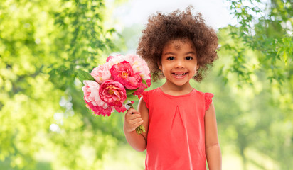 Wall Mural - childhood and people concept - happy little african american girl with flowers over green natural background