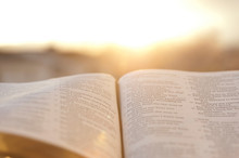 Open Bible With Bright Sunset In The Background. Close-up. Horizontal Shot.