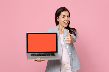 Cheerful woman in striped jacket showing thumb up holding laptop pc computer with blank empty screen isolated on pink pastel background. People sincere emotions, lifestyle concept. Mock up copy space.