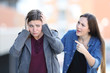 © Antonioguillem - Girl accusing her sad friend in the street