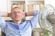 © Monika Wisniewska - Man suffers from heat in the office or at home