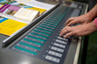Operator on offset print machine make a color corection on fountain control key unit.