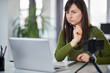 © nenadaksic - Beautiful serious Caucasian businesswoman sitting in modern office and using laptop.