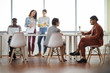 © Seventyfour - Diverse group of contemporary business people working at table in office, copy space