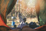 Fototapeta  - wanderlust outdoor camping - traveler feet out of the tent