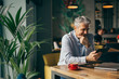 © cherryandbees - middle aged entrepreneur using tablet in cafe bar