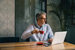 © cherryandbees - always online with his clients. man working on coffee break