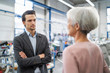 © Westend61 - Smiling businessman and senior businesswoman talking in a factory