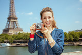 Fototapeta Paryż - solo traveller woman taking photos with retro photo camera