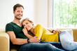 © Westend61 - Couple sitting on couch in their new home, cuddling