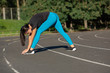 © vpavlyuk - Tanned slender girl stretching before running at the stadium. Outdoor shot with sun rays. Space for text