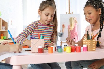 Sticker - Cute little children drawing at painting lesson indoors