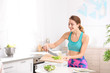 © New Africa - Young woman in fitness clothes preparing healthy breakfast at home. Space for text