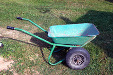 Green Color Metal Steel Dirty Old Garden Wheelbarrow Side View With Black Inflatable Wheel Closeup