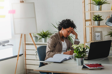 Wall Mural - Serious african-american business woman working on laptop at office