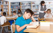 © JackF - Tired boy reading textbooks in school library