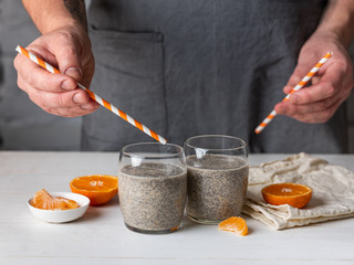 Wall Mural - Cooking dessert ingredients with chia, milk and citrus orange on white background. Recipe steps by steps concept.