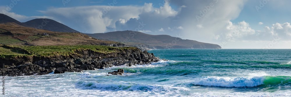 a view of the wild atlantic way off the coast of the ring of kerry in ireland showing skellig michael and surrounding islands in beautiful strong light with cloudy skies  - obrazy, fototapety, plakaty 