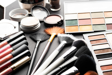 Multiple cosmetic products on black background. High resolution image for cosmetics and fashion industry.