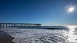 Wide view of long pier at the ocean over a sandy beach in the early morning. Photo by: Chuck Beyer