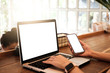 © Thaspol - Mockup image of a businesswoman using laptop with blank white desktop screen with coffee cup on wooden table in cafe