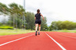 © Surasak - portrait of beautiful young female athlete running on running track (back view) on blur background