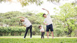 © paulaphoto - Family exercising and jogging together at the park. Group of asian family father mother and daughter stretching after sport on the grass. Sport health care and medical concept.