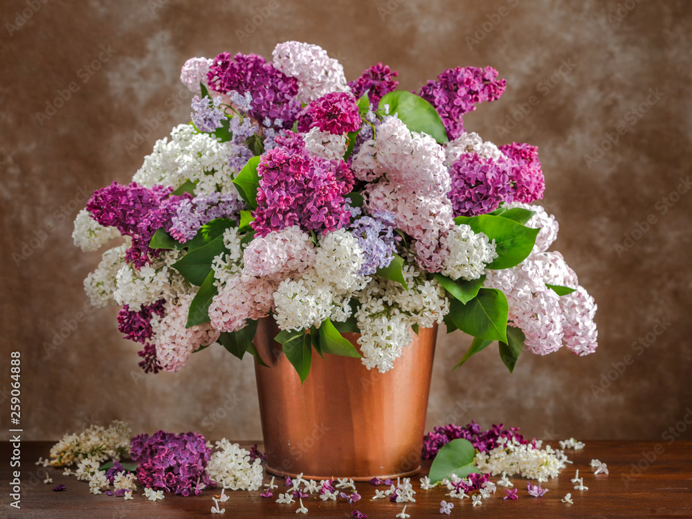 Still life lilac flowers in a vase on the table. - obrazy, fototapety, plakaty 