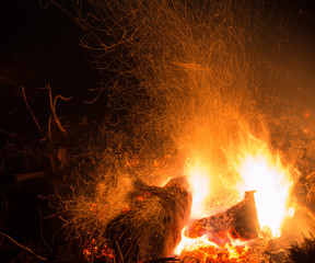 Burning fire in the night. Flame and fire sparkles on a dark abstract background. Hellish element of fire. Fuel, power and energy