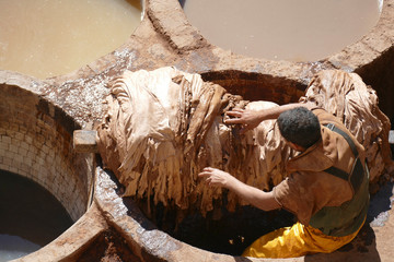 workers prepare hides in pits of the leather tannery