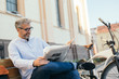 © cherryandbees - relaxing time in city. man reading newspaper in city , bicycle in blurred background