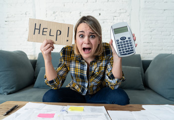 Portrait of stressed and overwhelmed young woman trying to manage home finances paying bills