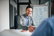 © bnenin - Good deal. Two business people shaking hands while sitting at the working place.