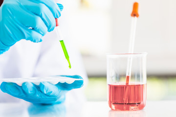 Scientist dropping liquid to sample tray..