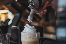 The Process Of Preparing A Delicious Coffee Drink With Whipped Cream That Is Decorated With Coffee With Milk