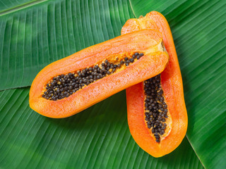 2 halves of Fresh Raw Exotic Tropical Thai Fruit Carica Papaya on Banana leaves