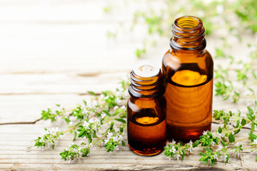 Wall Mural - thyme essential oil and thyme flowers on the wooden board