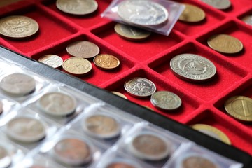 Numismatic, world coins collection on a red tray.