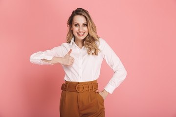 Poster - Portrait of beautiful woman smiling and showing thumb up isolated over pink background