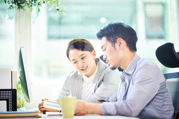 two asian business people working together in office