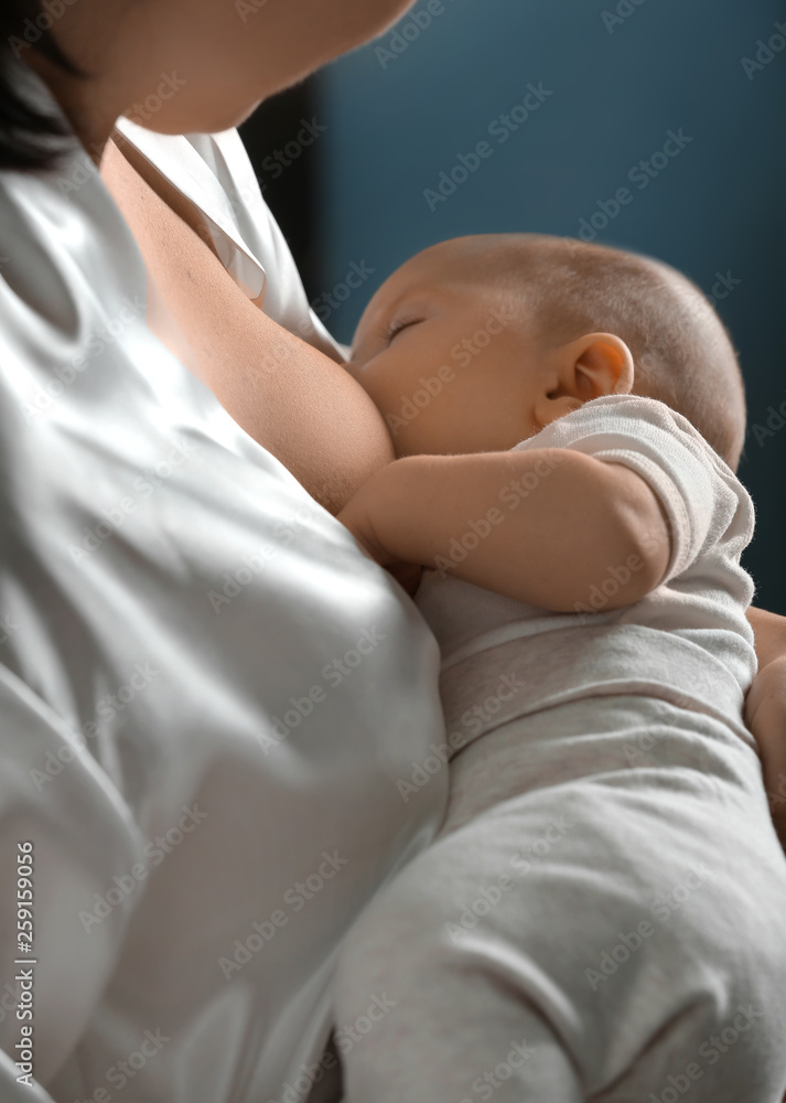 Young woman breastfeeding her baby at home