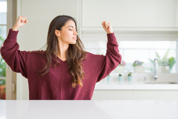 Sticker - Young beautiful woman at home showing arms muscles smiling proud. Fitness concept.