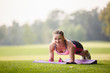 © Olga Mishyna - sport girl making exercises outdoors. Young sport woman in a park. Sport and fitness on open air. Exercise lunge leg on the grass and stretching