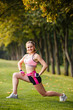© Olga Mishyna - sport girl making exercises outdoors. Young sport woman in a park. Sport and fitness on open air. Exercise lunge leg on the grass and stretching