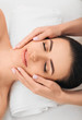 © Peakstock - young woman getting a head massage at a spa. Face massage with perfect clean and fresh skin