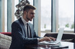 © Cressida studio - Young businessman working on a plan of Internet project on the laptop. Man discusses business matters by phone. Working computer for internet research. Digital marketing. Development